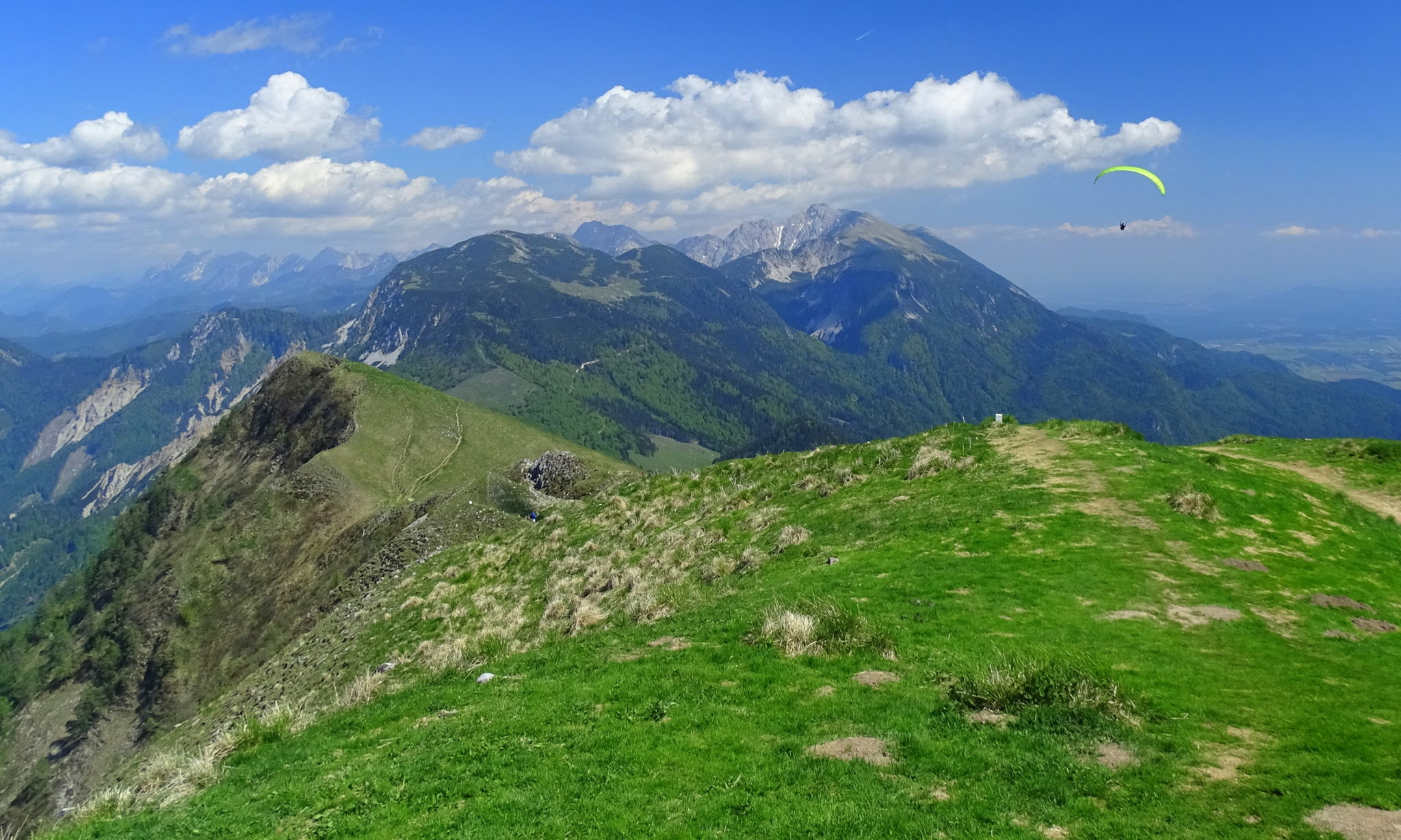 A paraglider flying over the mountains; Golica, Slovenia