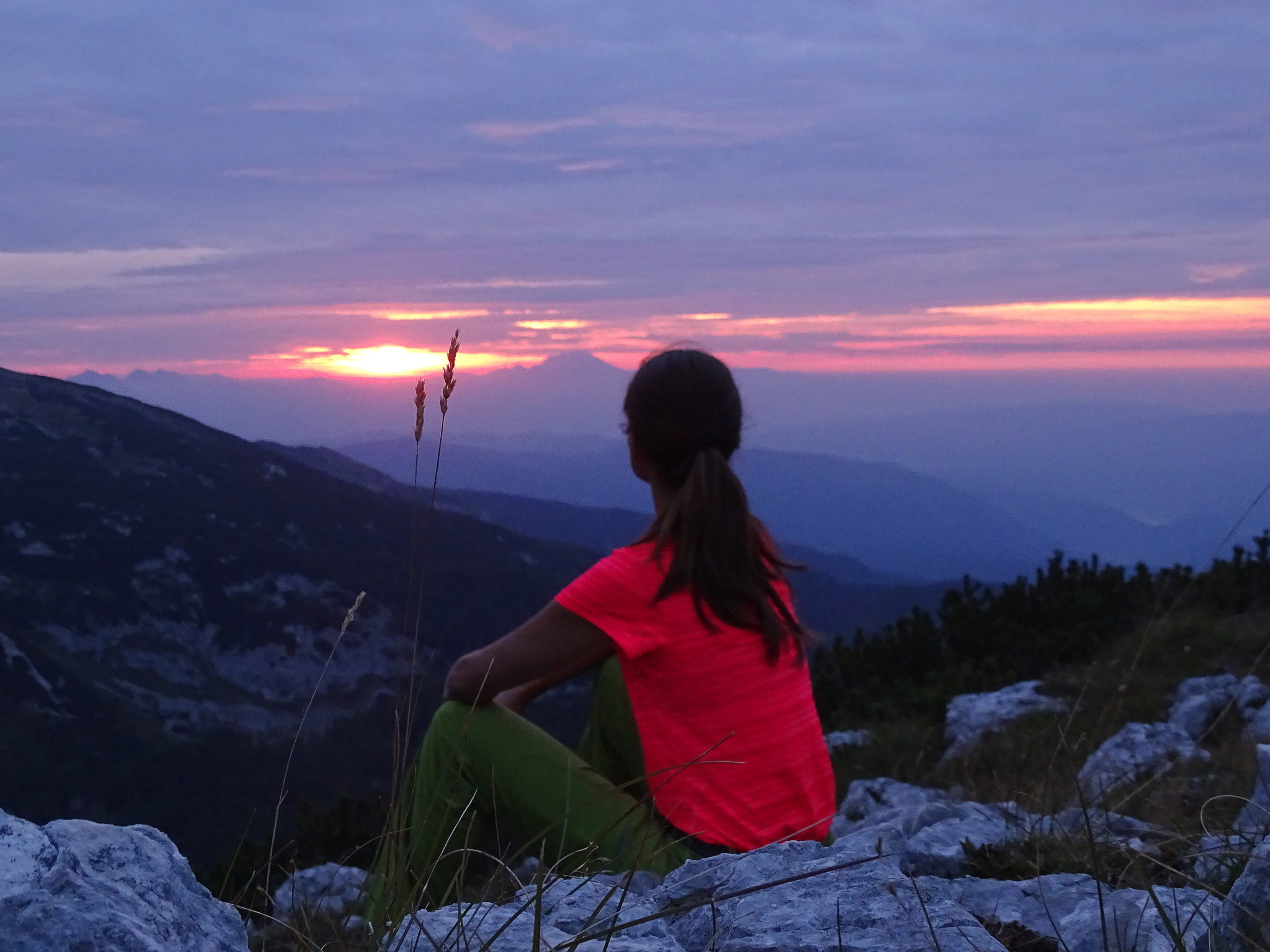 A female hiker expecting sunrise from Mala Tičarica above Triglav lakes, Slovenia