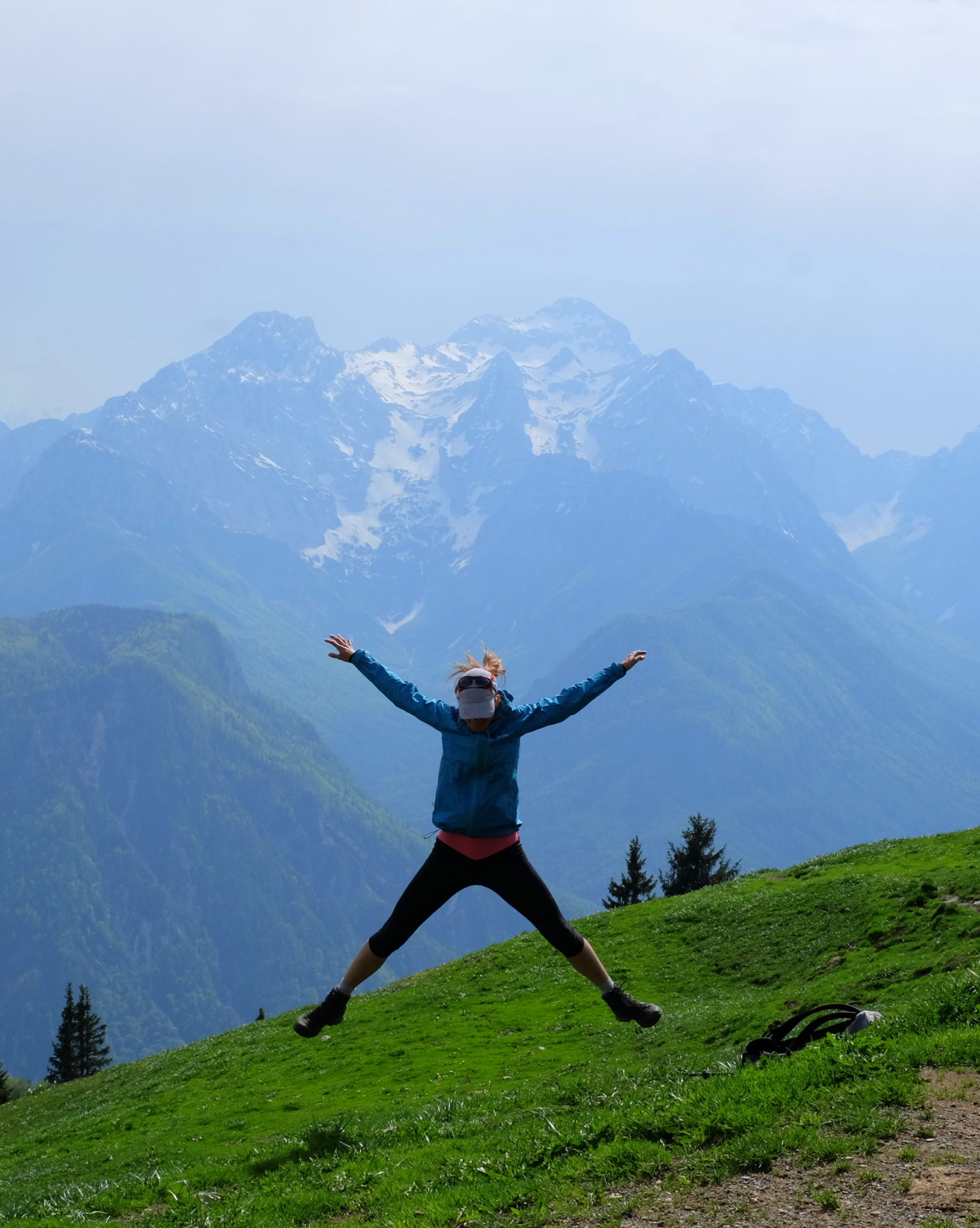 A female hiker jumping from joy in the mountains
