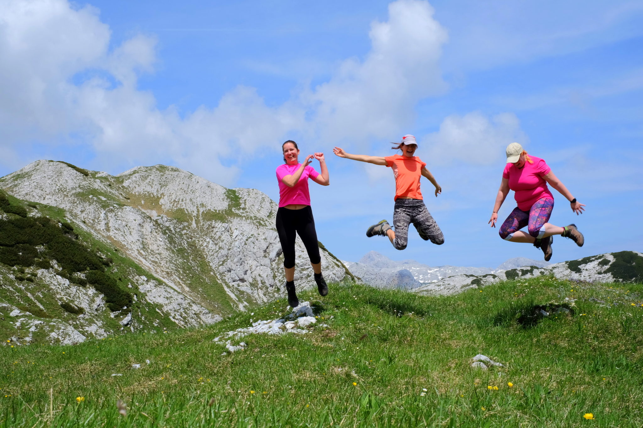 Three women hikers jumping in the mountains, Slovenia, Triglav National Park